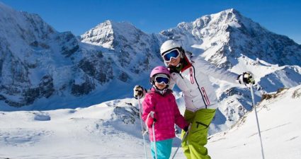 Frau mit Kind beim Ski fahren in den Alpen