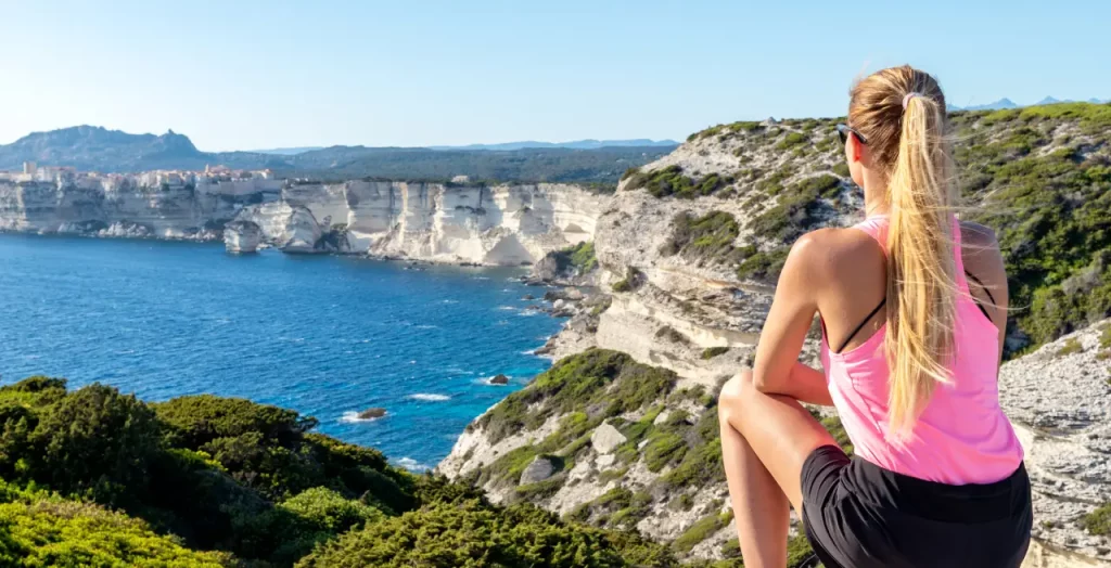 Frau betrachtet die Klippen von Bonifacio auf Korsika, Frankreich, mit Meerblick