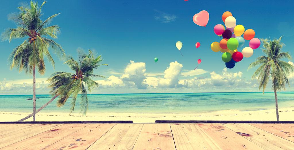 Luftballons zur Hochzeit am Strand unter Palmen