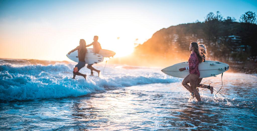Freunde surfen zum Sonnenuntergang im Meer von Australien
