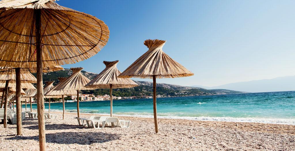 Strand mit Sonnenschirmen auf der Insel Krk, Kroatien