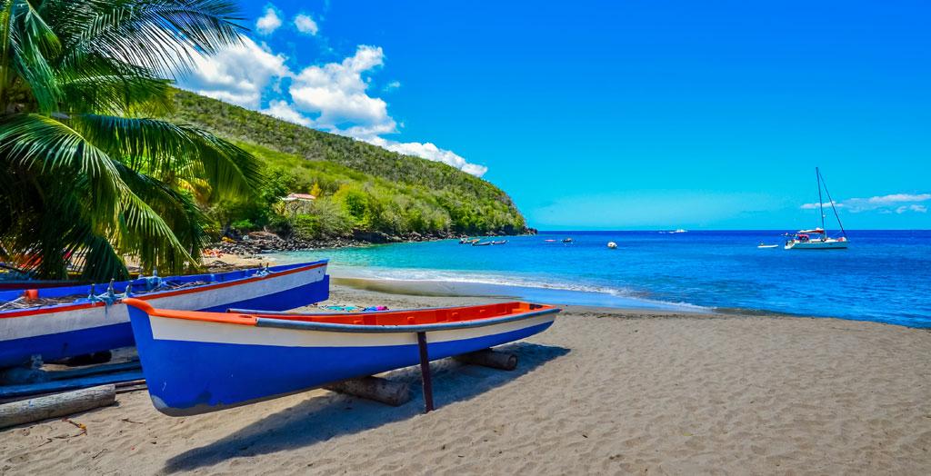 Boote am karibischen Strand mit Palmen