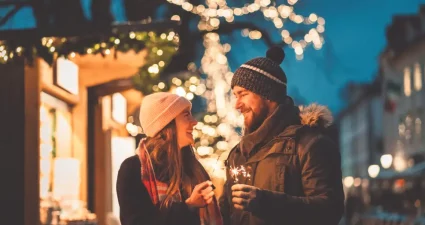 Paar hält eine Wunderkerze auf dem Weihnachtsmarkt