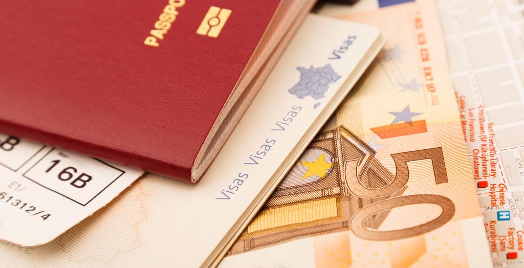 Reisepass, Geld und Flugtickets liegen auf einer Landkarte