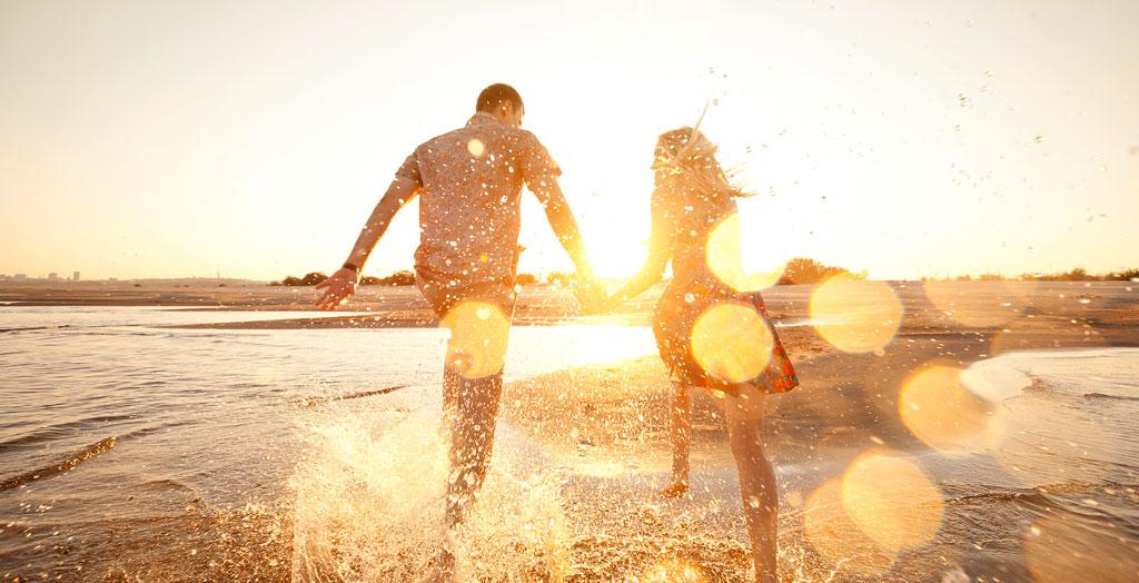 Paar am Strand zum Sonnenuntergang