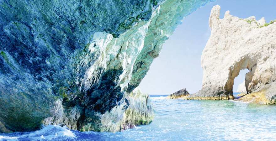 tiefblaues meerwasser reflektiert auf felsen einer höhle