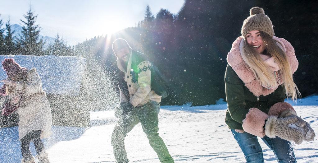 Freunde haben Spaß im Schnee bei einer Schneeballschlacht