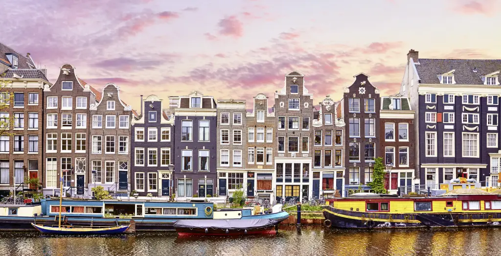 Bunte Häuserfassaden und Hausboote im Jordaan-Viertel in Amsterdam bei Sonnenuntergang