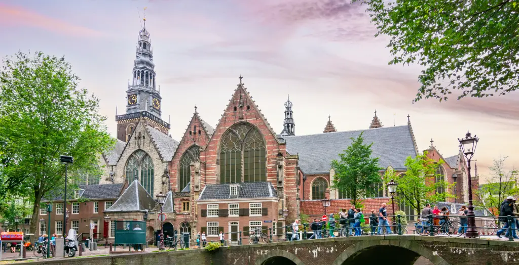 Die Oude Kerk in Amsterdam, Niederlande, mit ihrer beeindruckenden Architektur und Menschen auf der Brücke
