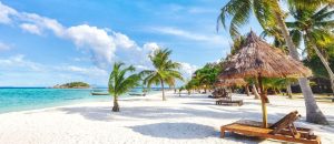 Leerer, sonniger Strand der Insel Koh Lipe mit hohen Palmen und Strandbungalows