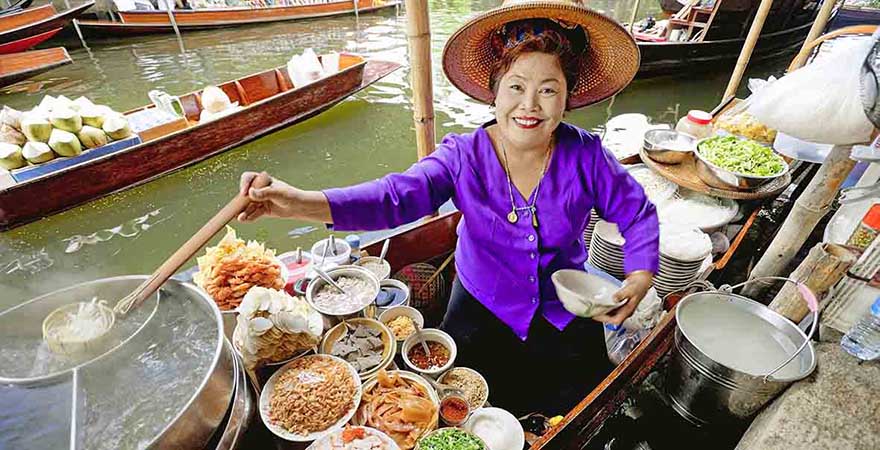 Schwimmender Markt. Frau auf einem Boot verkauft Essen. 