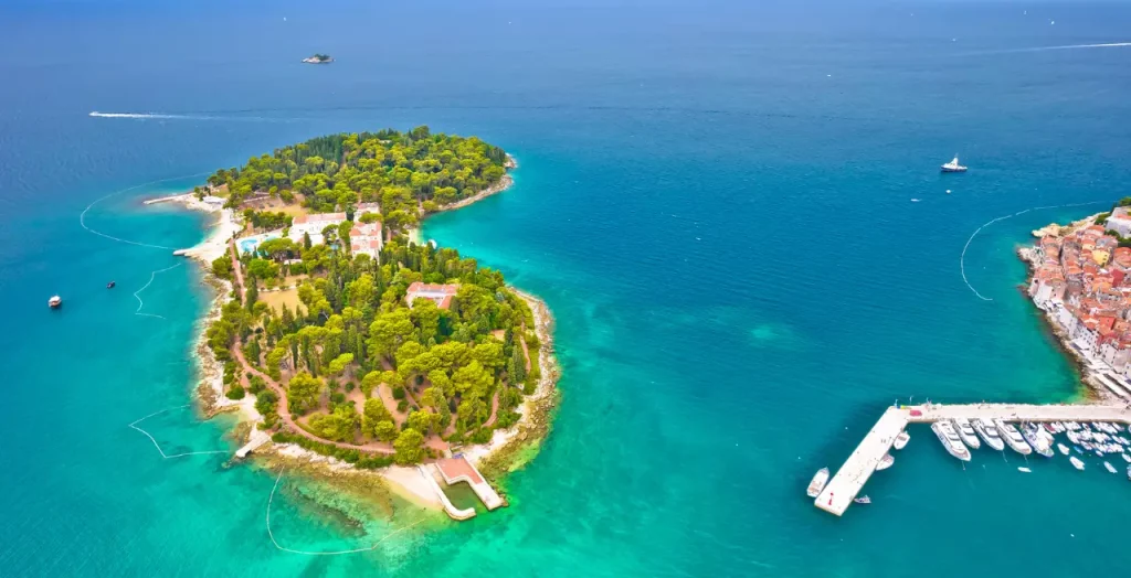 Luftaufnahme der Insel Katarina nahe Rovinj in Kroatien mit kristallklarem Wasser und Yachthafen [Bildquelle: © xbrchx | Canva]