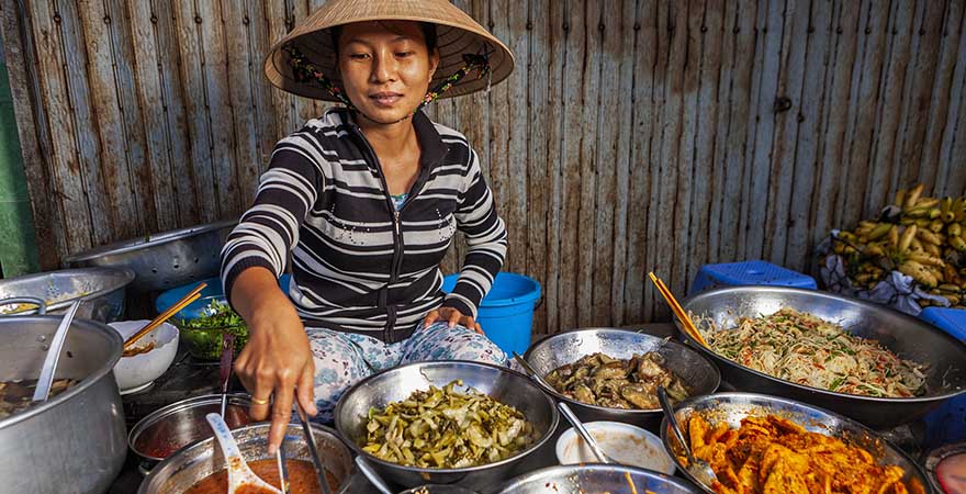 Asiatische Frau kocht auf dem Markt