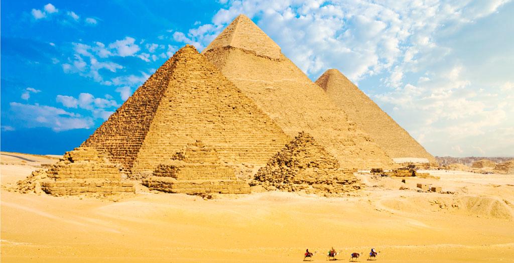 Eine Kamelkarawane steht vor den Pyramiden in Kairo, Ägypten