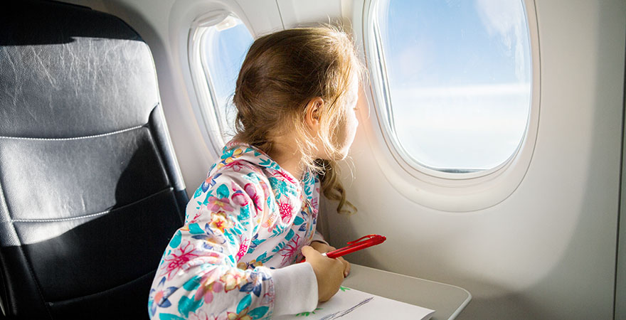 Mädchen schaut aus einem Flugzeugfenster