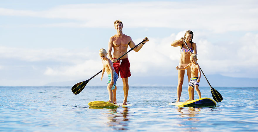 Mann, Frau und 2 Kinder auf Stand-up-Paddleboards