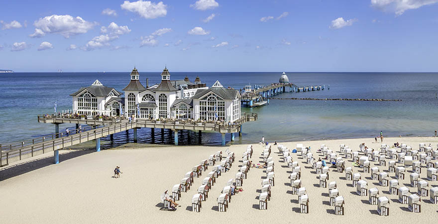 Strand von Sellin auf Rügen mit einem Restaurant auf einem Steg und Strandkörben im Sand