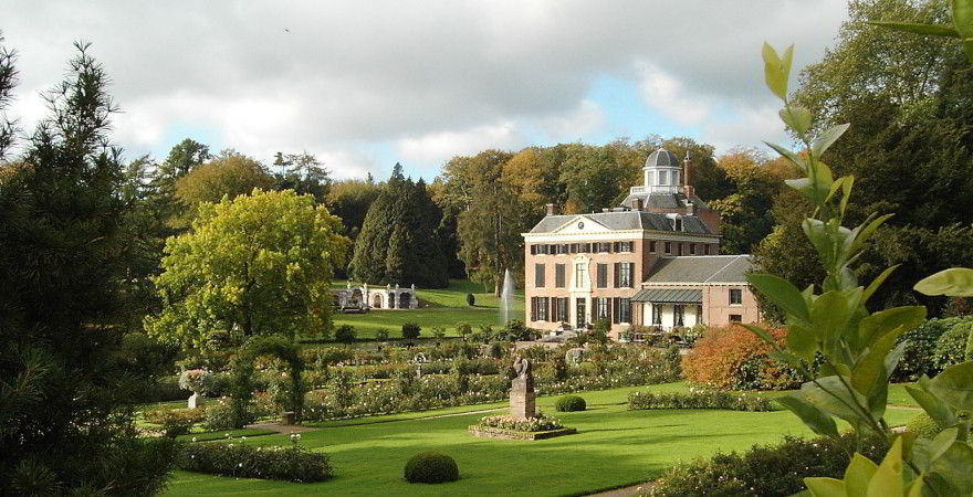 Rechts im Bild ist das Anwesen Rosendael zu sehen. Umgeben ist dieses Schloss von einem schönen Garten, Grünflächen, einem Bogen und Pflanzen, im Hintergrund neben dem Schloss befindet sich eine Wasserfontäne.