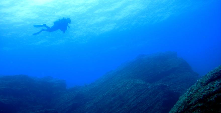 taucher in unterwasserfelsenlandschaft
