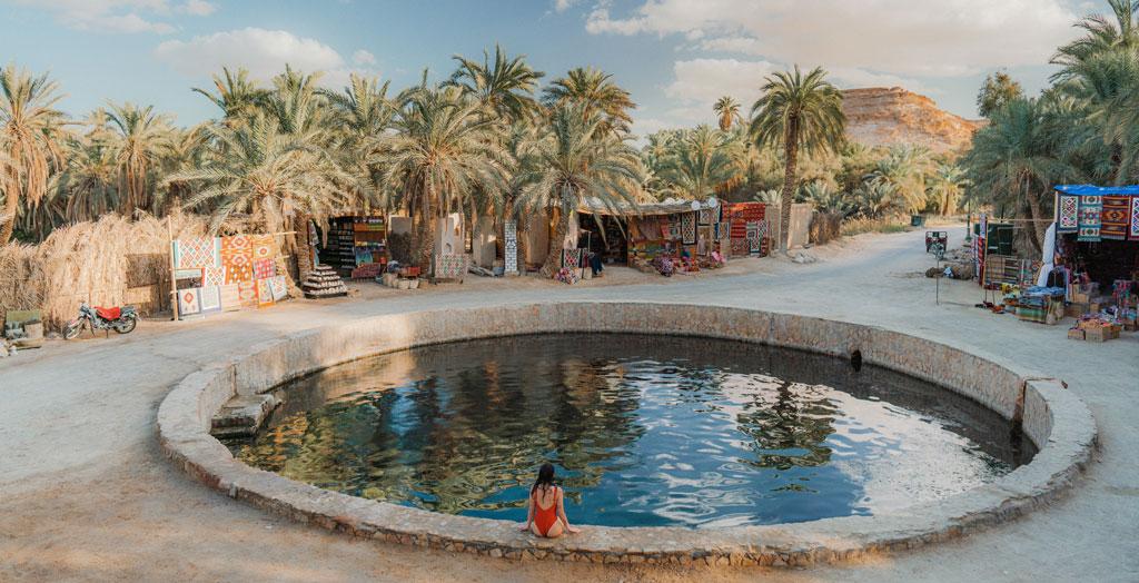 Frau schwimmt in der Kleopatra-Quelle in der Oase Siwa, Ägypten