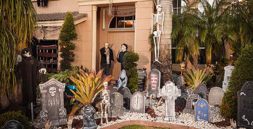 Haus mit Halloweendeko viele Grabsteine und Skelette