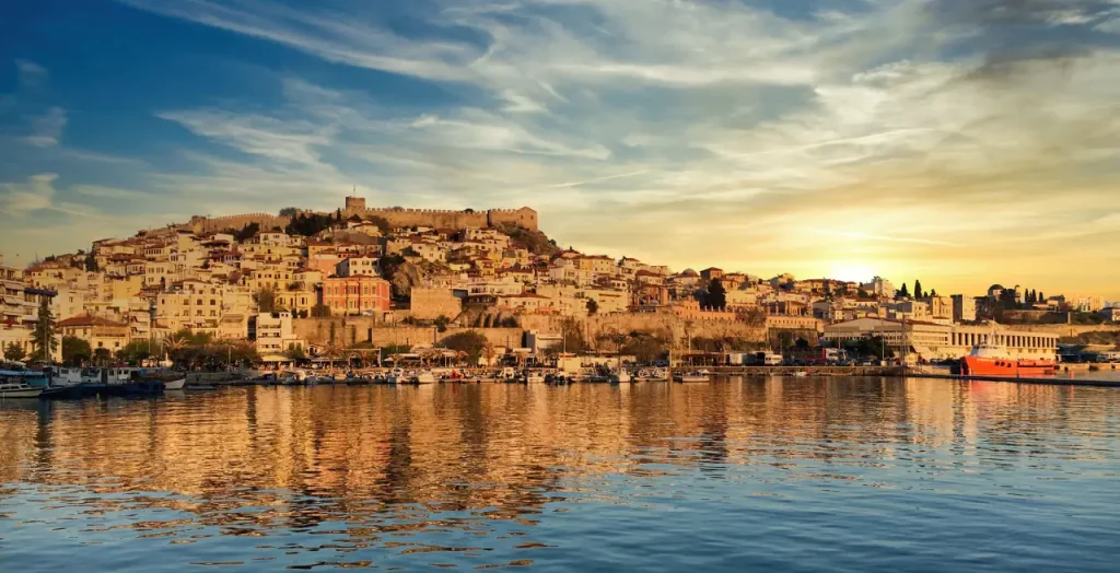 Sonnenuntergang beleuchtet die historische Stadt Kavala in Griechenland mit Reflexion im Wasser