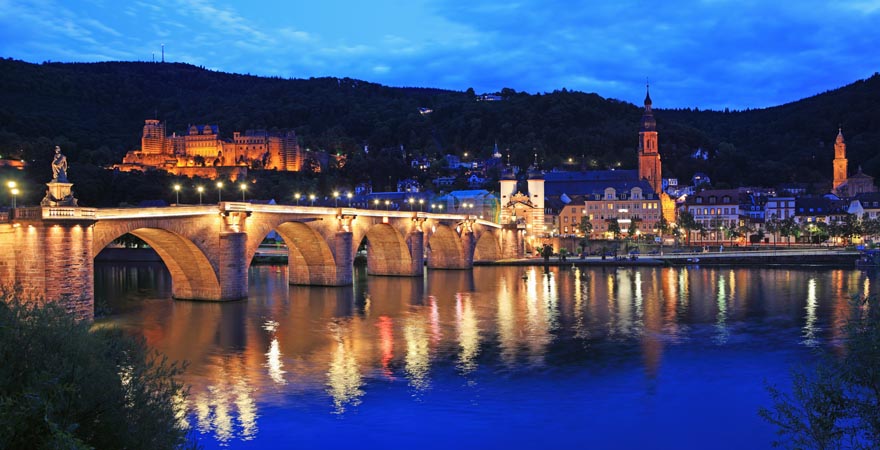 Ausblick auf die alte Brücke und Heidelberger Schloss an der Neckar in der Abenddämmerung