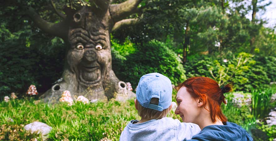 Mutter und Kind bestaunen Baum mit Gesicht im Phantasialand in Brühl