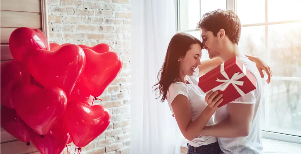 Ein junges Paar mit Geschenken und Luftballons zum Valentinstag