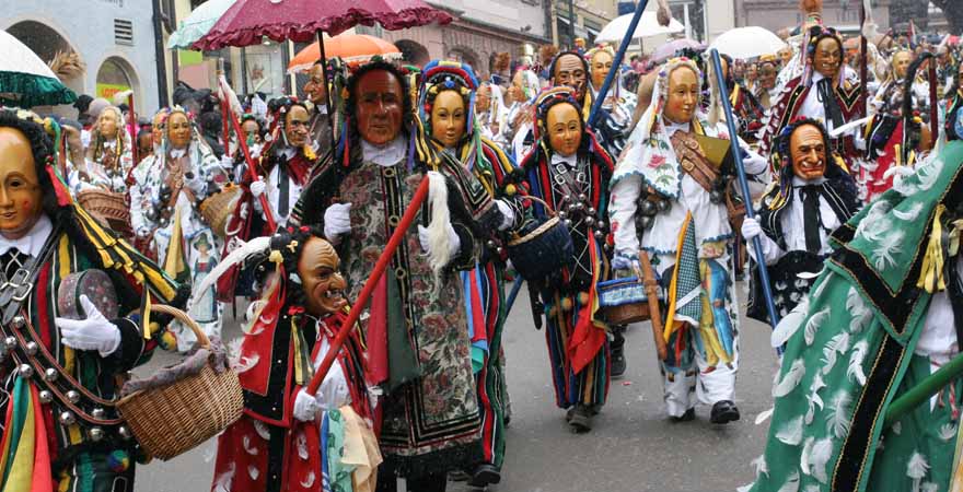 Traditionelle Kostüme mit Masken bei einem Karnevalsumzug in Rottweil