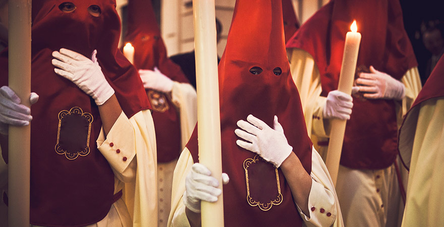 Vermummte Personen mit Spitzkapuzen während der Semana Santa in Sevilla Spanien
