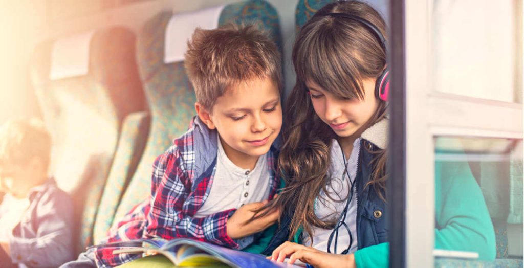 Zwei Kinder hören Musik im Zug