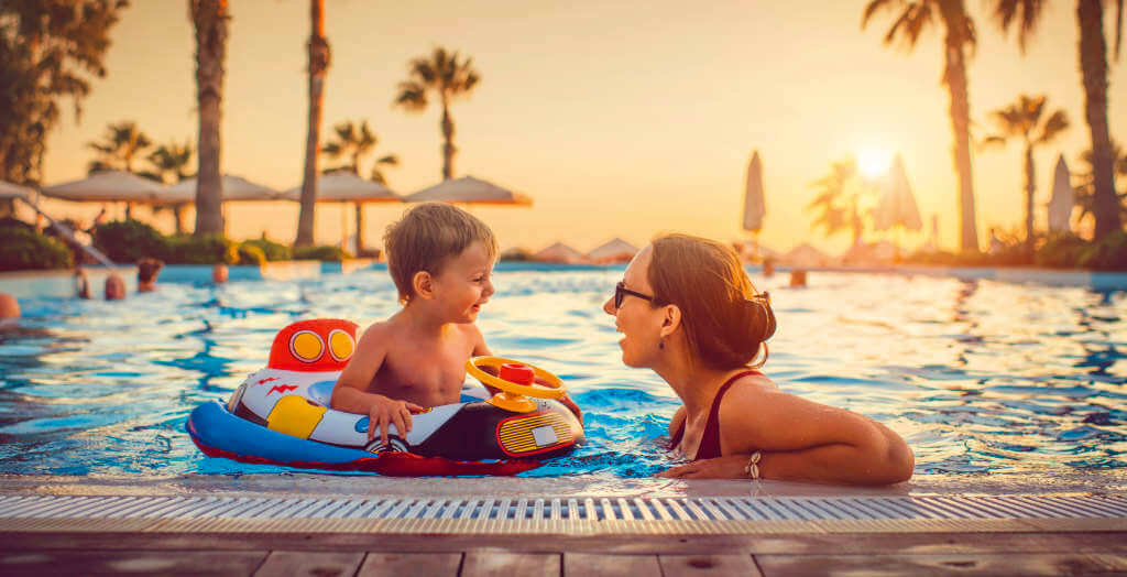 Mutter mit Kind im Pool eines Hotels