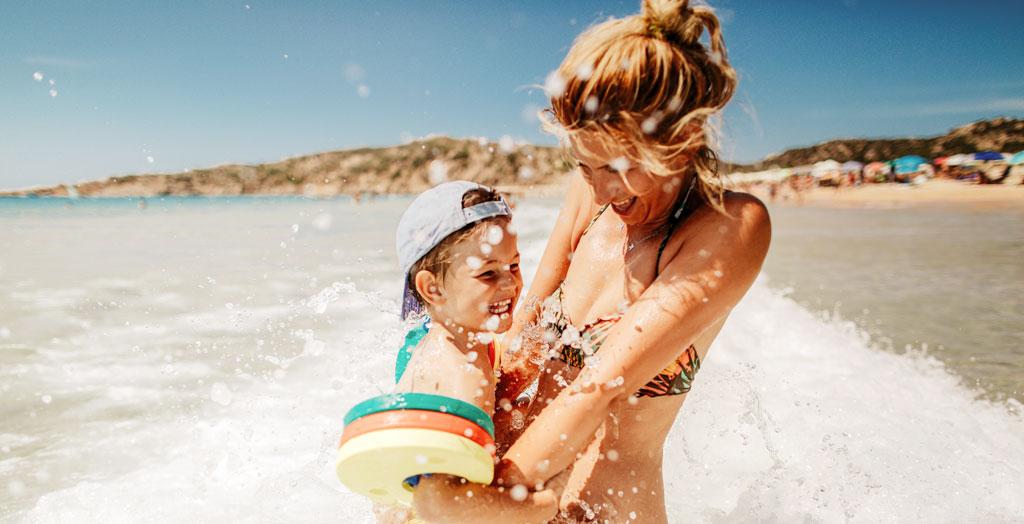 Frau mit Kind badet im Meer