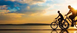 Freunde fahren Fahrrad bei Sonnenuntergang