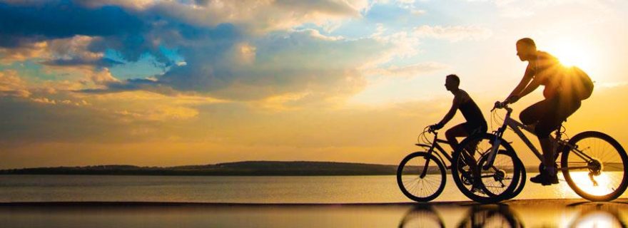 Freunde fahren Fahrrad bei Sonnenuntergang