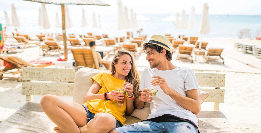 Paar entspannt mit Cocktail am Strand