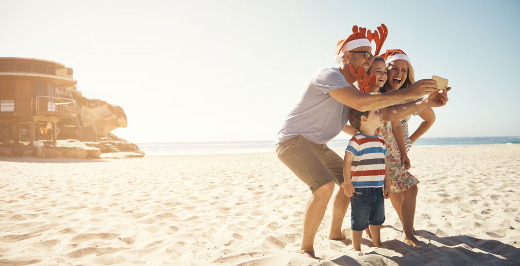 Familie nimmt an Weihnachten am Strand ein Selfie auf