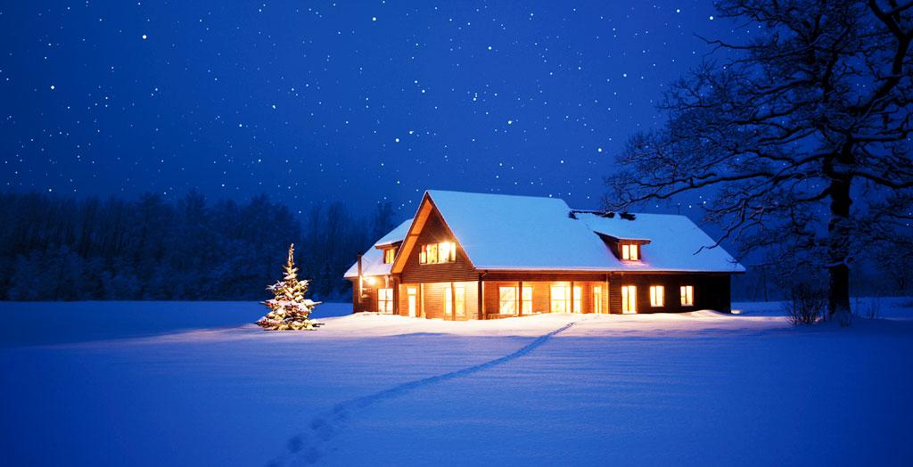 Beleuchtetes Haus mit Weihnachtsbaum im Winter