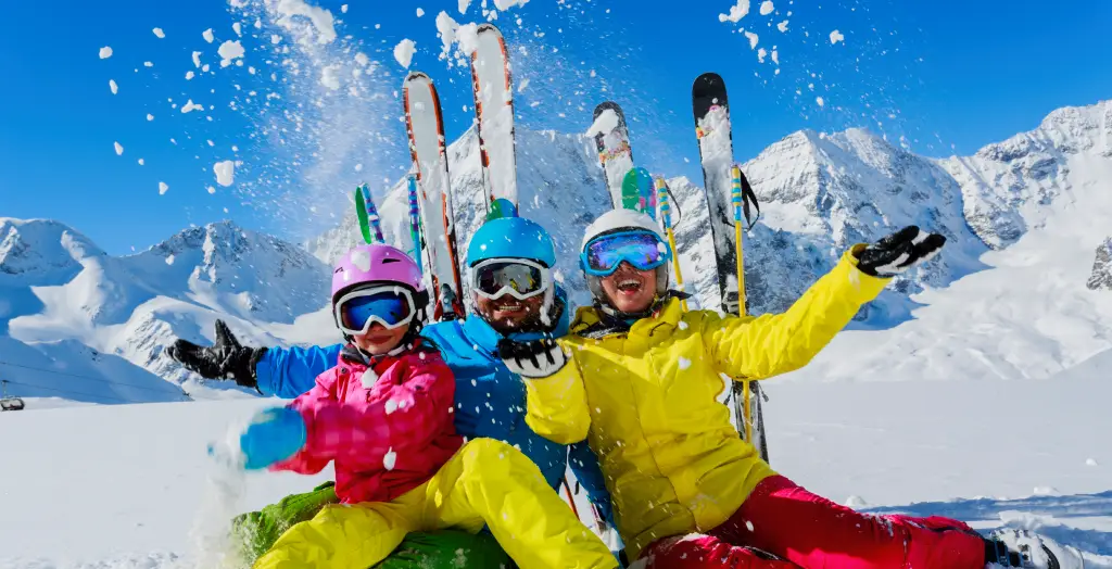 Familie genießt den Winter mit Ski fahren im Schnee der Alpen