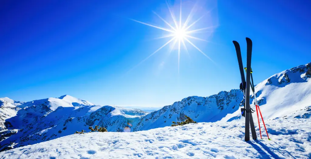 Skier und Skistöcke auf der Piste in den Alpen