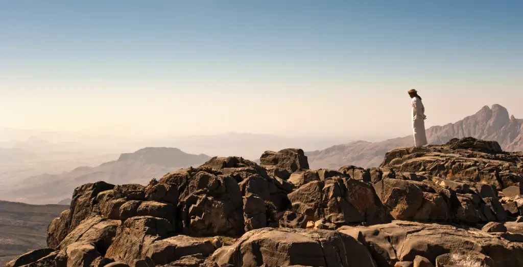 Ein Mann blickt vom höchsten Berg Omans dem Jabal Sham herab © Ministry of Heritage & Tourism Sultanate of Oman