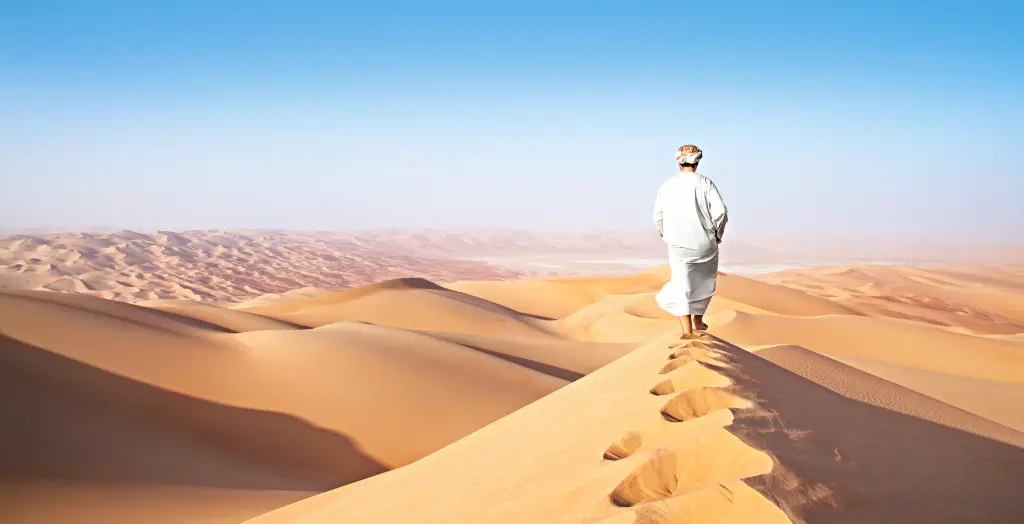 Mann beim Spaziergang in der Rub' al-Khali Wüste im Oman 