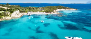 Atemberaubende Luftaufnahme der Bucht Cala Mariolu mit klarem türkisfarbenem Wasser und verankerten Booten, Sardinien, Italien
