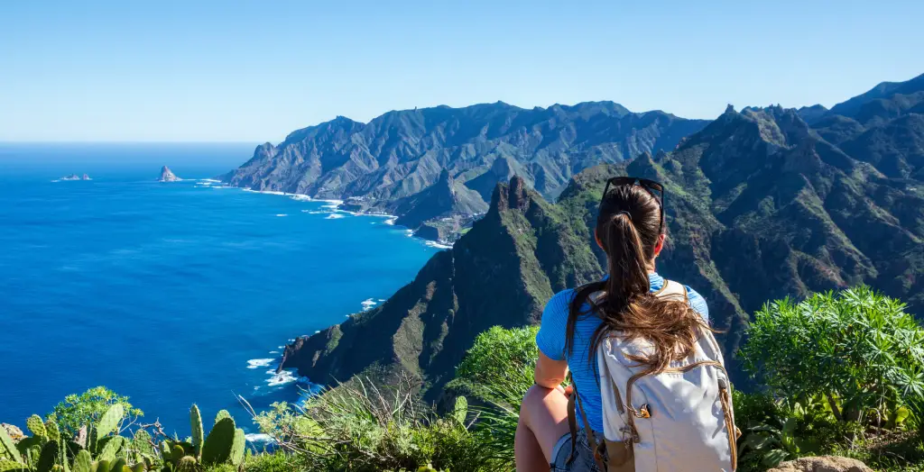 Frau mit Rucksack genießt die Aussicht auf das Anaga-Gebirge und das blaue Meer auf Teneriffa, Kanarische Inseln, Spanien
