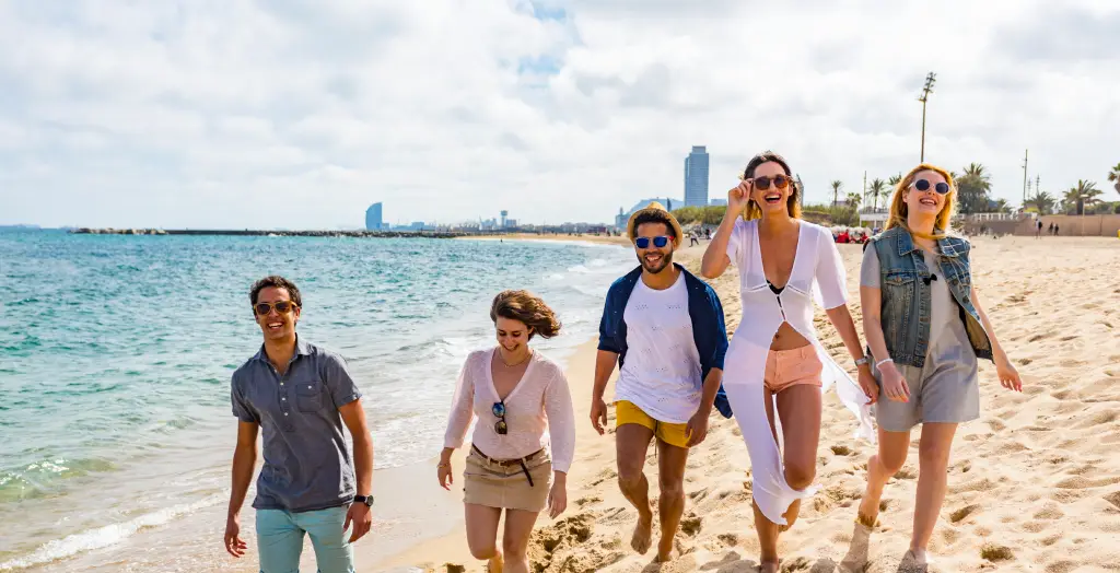 Gruppe von Freunden genießt einen Spaziergang am Strand von Barcelona, Spanien