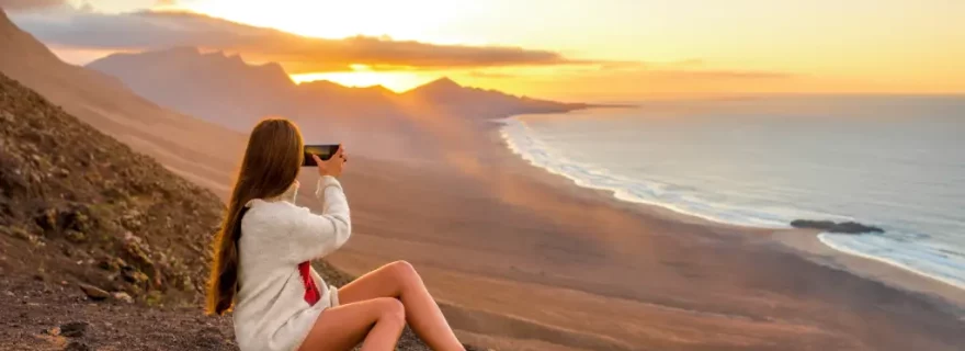 Junge Wanderin fotografiert den Sonnenuntergang im Naturpark Jandía, Fuerteventura, Kanaren