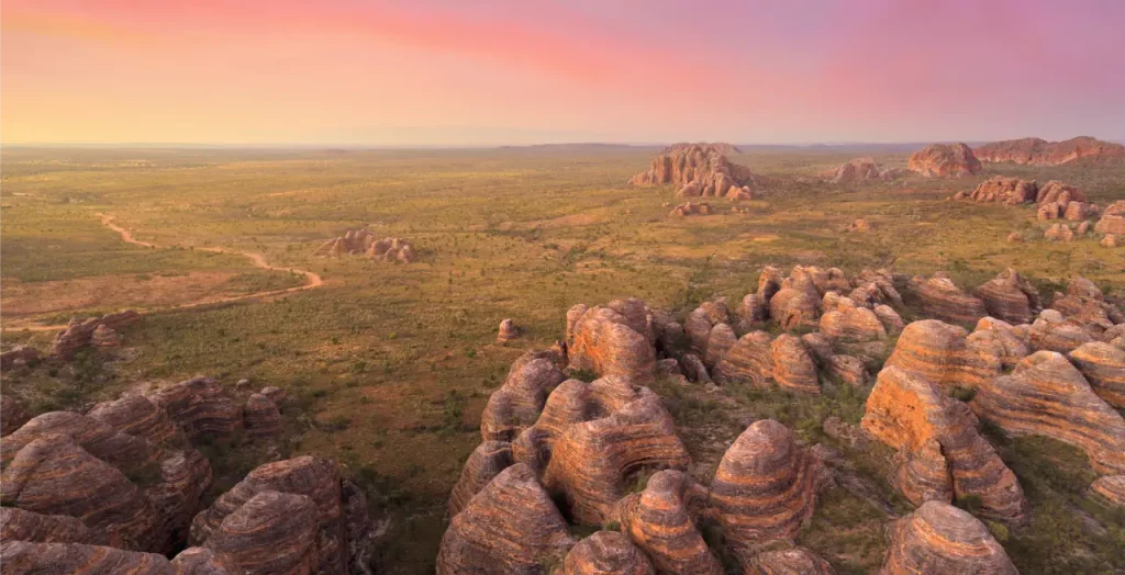 Sonnenuntergang über der Bungle Bungle Range im Purnululu-Nationalpark, Westaustralien, mit charakteristischen bienenkorbartigen Felsformationen [Bildquelle: © Tourism Western Australia]