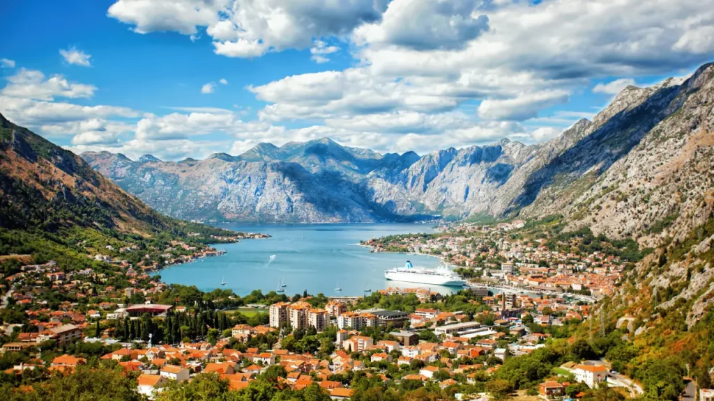 Atemberaubende Ansicht der Bucht von Kotor in Montenegro mit historischer Stadtlandschaft, azurblauem Wasser und dramatischen Bergkulissen