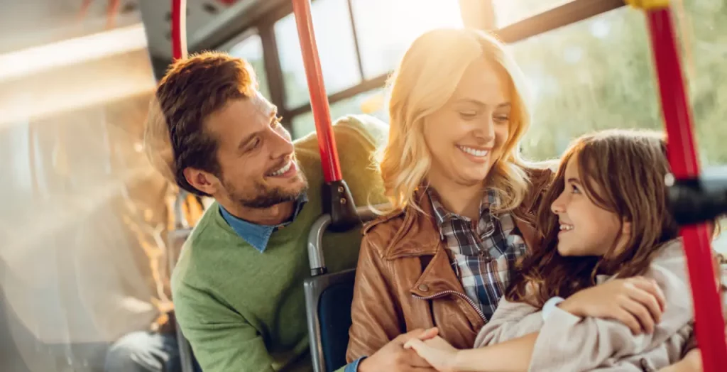 Glückliche Familie genießt gemeinsame Busreise, sonniges Lächeln im Gesicht [Bildquelle: © Geber 86 | Canva]